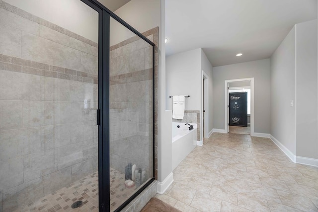 full bath featuring baseboards, a garden tub, and a shower stall