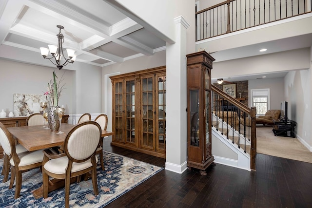 dining area with beamed ceiling, coffered ceiling, hardwood / wood-style floors, stairway, and an inviting chandelier