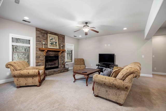 living area with a fireplace, light colored carpet, visible vents, and a wealth of natural light