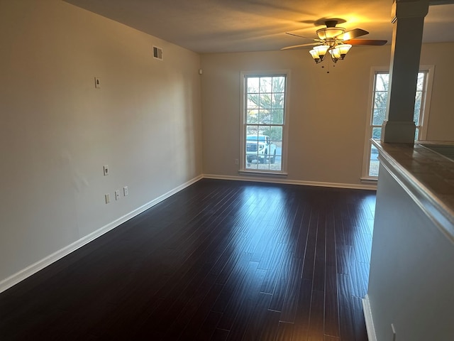 empty room with ceiling fan and dark hardwood / wood-style flooring