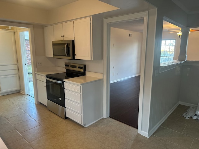 kitchen with stainless steel appliances, white cabinets, ceiling fan, and light tile patterned floors