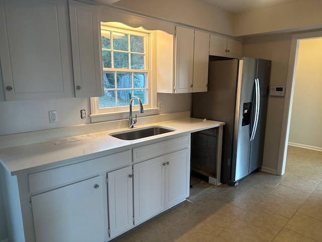 kitchen featuring white cabinets, stainless steel refrigerator with ice dispenser, and sink