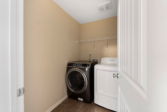 laundry area with dark tile patterned flooring, baseboards, visible vents, laundry area, and washing machine and clothes dryer