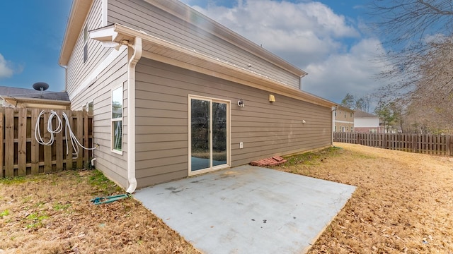 back of property with fence and a patio area