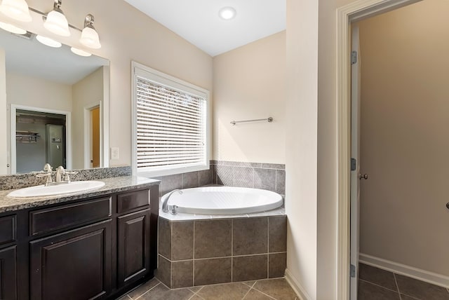 bathroom featuring tile patterned flooring, a bath, and vanity