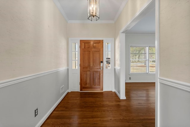 foyer with dark hardwood / wood-style flooring, ornamental molding, and a notable chandelier