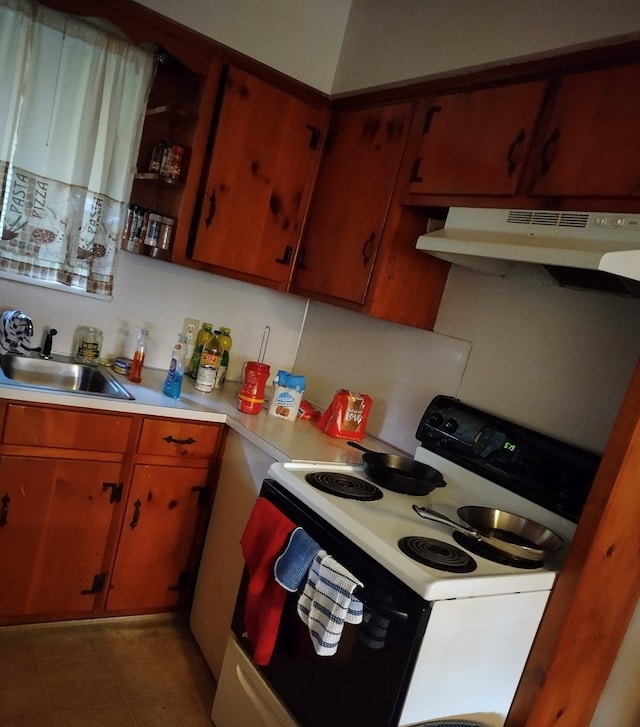 438 Claradon Ave, Columbus, GA 31906 - kitchen featuring white electric stove, under cabinet range hood, light countertops, tile patterned floors, and brown cabinetry