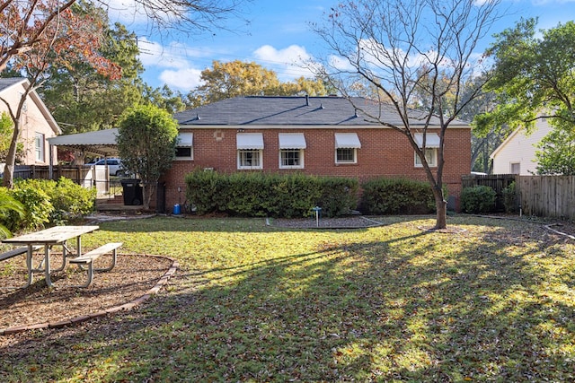 rear view of property featuring a lawn