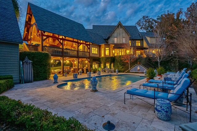 pool at dusk featuring a patio area