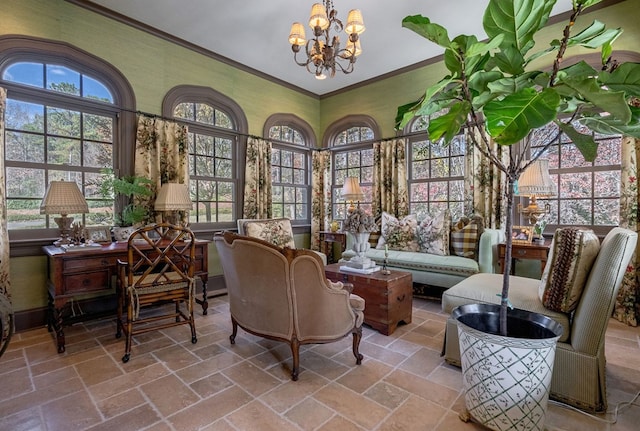 sitting room with ornamental molding and a notable chandelier