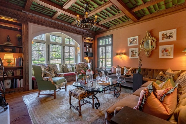 living room with beamed ceiling, built in features, wood-type flooring, and a chandelier