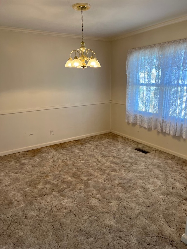 spare room featuring carpet floors, an inviting chandelier, visible vents, and ornamental molding