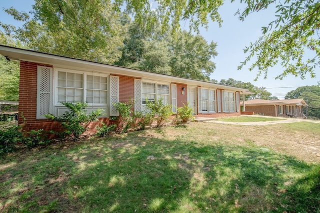 ranch-style house with brick siding and a front lawn