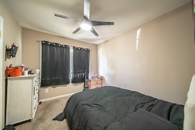 bedroom featuring a ceiling fan, light colored carpet, and baseboards