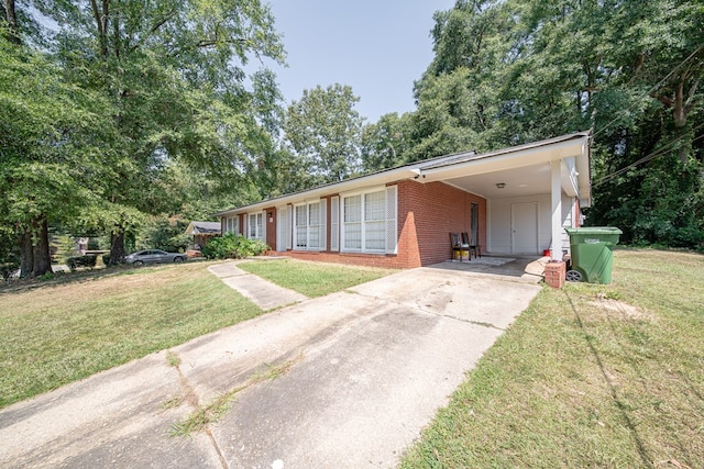 ranch-style house featuring a front yard, concrete driveway, brick siding, and an attached carport