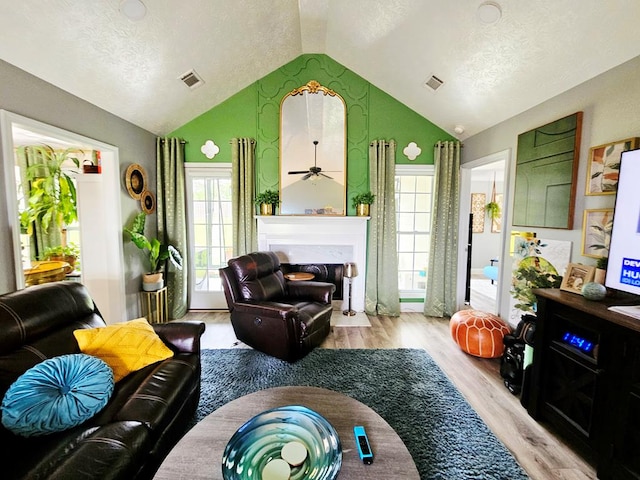 7 Hillside Ct, Phenix City, AL 36870 - living room featuring light wood finished floors, lofted ceiling, a fireplace, and a textured ceiling