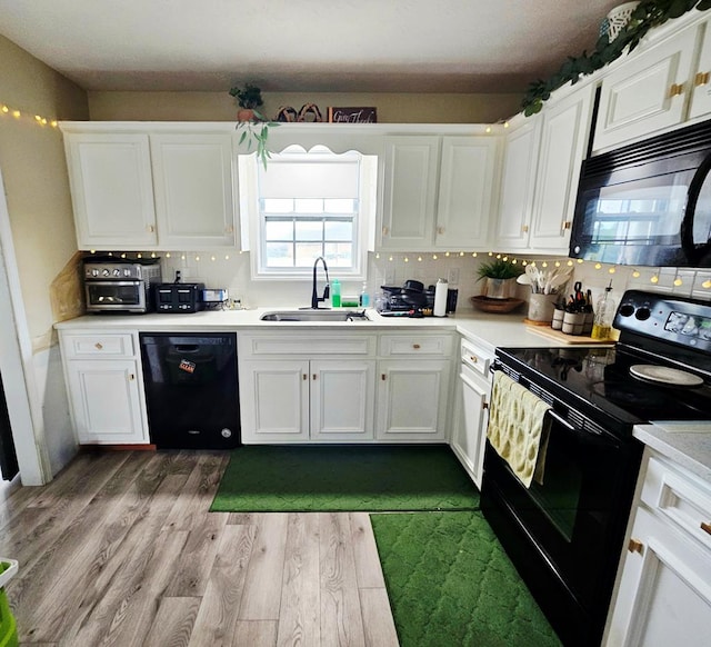 7 Hillside Ct, Phenix City, AL 36870 - kitchen featuring black appliances, white cabinetry, wood finished floors, light countertops, and tasteful backsplash