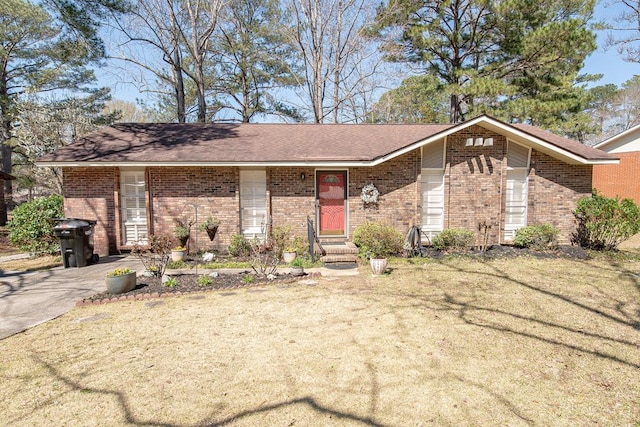 view of front facade featuring brick siding and a front yard