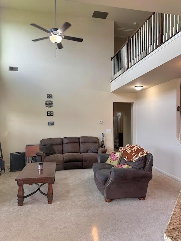 7613 Mockernut Way, Midland, GA 31820 - carpeted living area featuring a high ceiling, ceiling fan, and baseboards