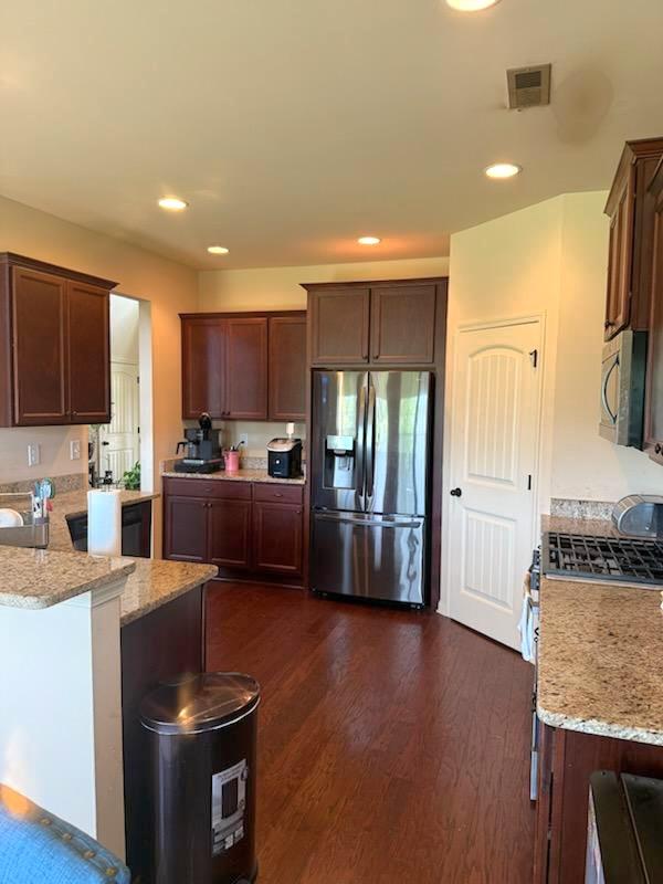 7613 Mockernut Way, Midland, GA 31820 - kitchen featuring appliances with stainless steel finishes, light stone countertops, dark wood-type flooring, a peninsula, and recessed lighting