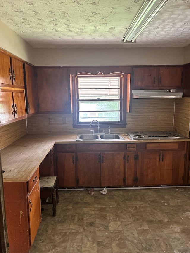 2908 Urban Ave, Columbus, GA 31907 - kitchen with a sink, under cabinet range hood, light countertops, dark flooring, and a textured ceiling