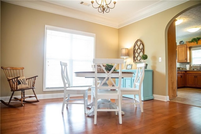 93 Pebble Ct, Smiths Station, AL 36877 - dining space featuring arched walkways, light wood-style flooring, ornamental molding, and a chandelier