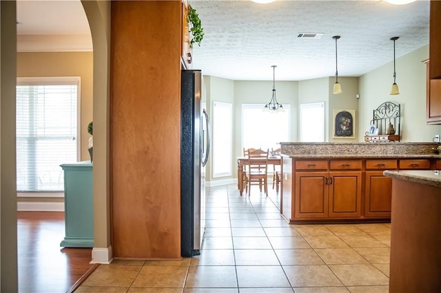 93 Pebble Ct, Smiths Station, AL 36877 - kitchen with brown cabinets, plenty of natural light, and freestanding refrigerator