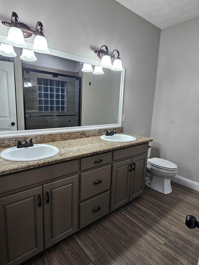 93 Pebble Ct, Smiths Station, AL 36877 - full bathroom with double vanity, tiled shower, and wood finished floors
