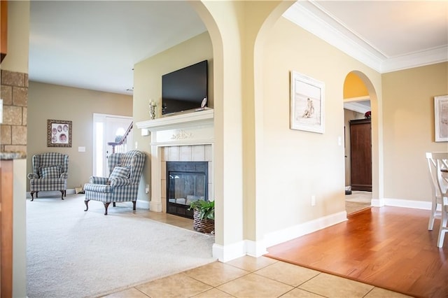 93 Pebble Ct, Smiths Station, AL 36877 - tiled living room featuring a tile fireplace, ornamental molding, and arched walkways
