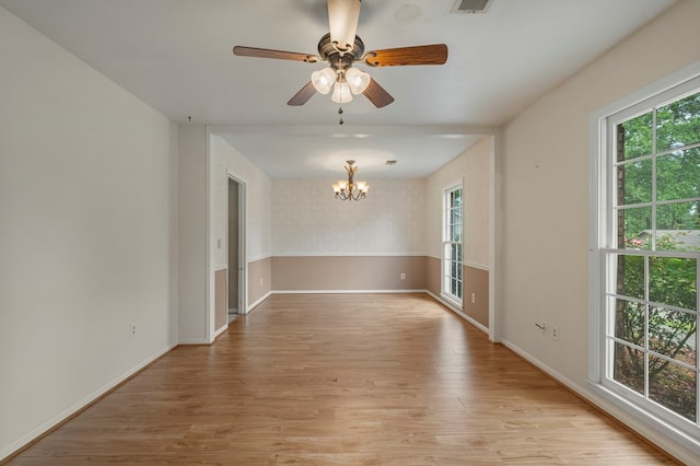 empty room with baseboards, visible vents, a healthy amount of sunlight, and light wood-style floors
