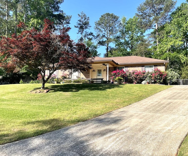 view of front of property with concrete driveway, a front yard, and covered porch