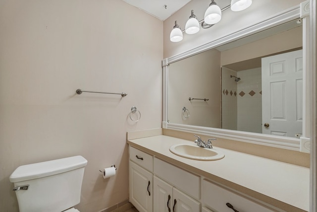 full bath with toilet, a tile shower, and vanity