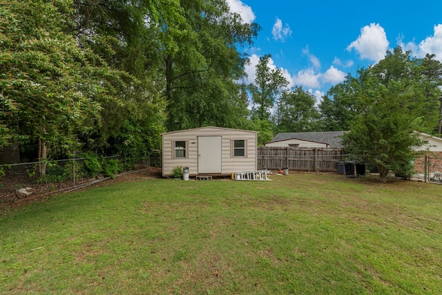 view of yard with an outdoor structure, a storage unit, and a fenced backyard