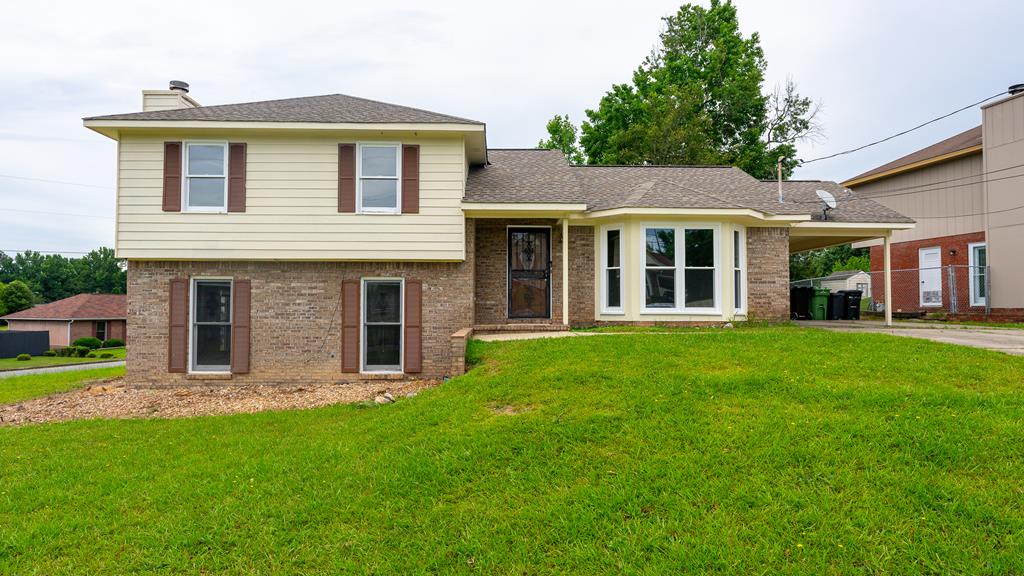 tri-level home with a carport and a front yard