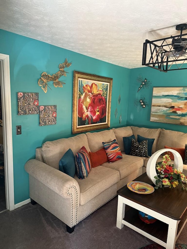 carpeted living room featuring baseboards and a textured ceiling