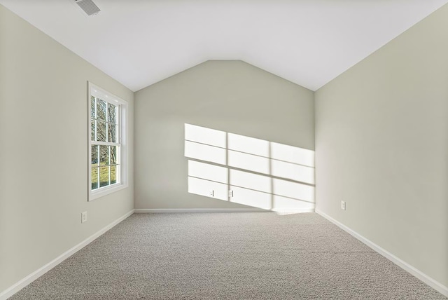 carpeted empty room featuring lofted ceiling