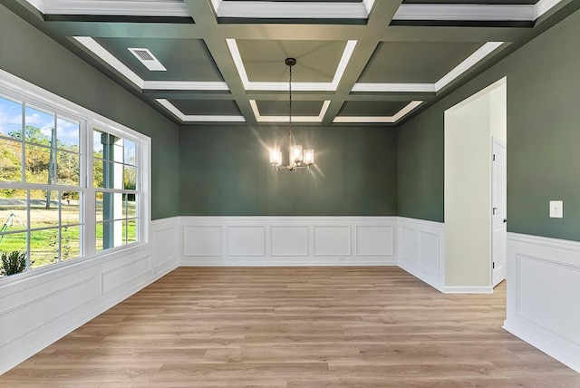 spare room featuring a wealth of natural light, beamed ceiling, a chandelier, and coffered ceiling