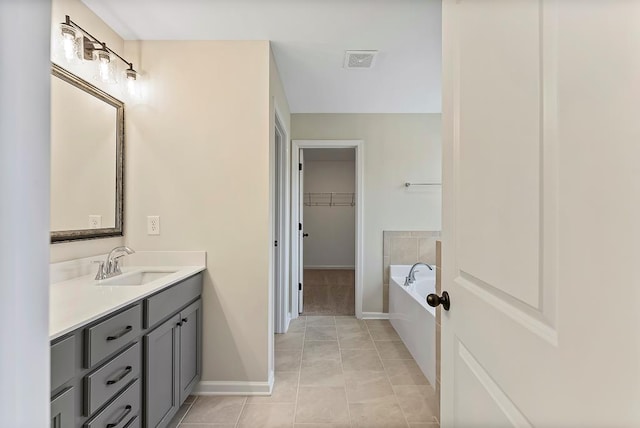 bathroom featuring a bathing tub, tile patterned flooring, and vanity