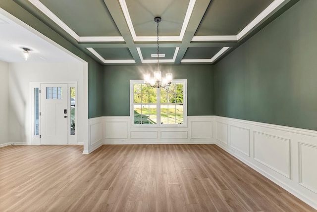 unfurnished room with a chandelier, beam ceiling, plenty of natural light, and coffered ceiling