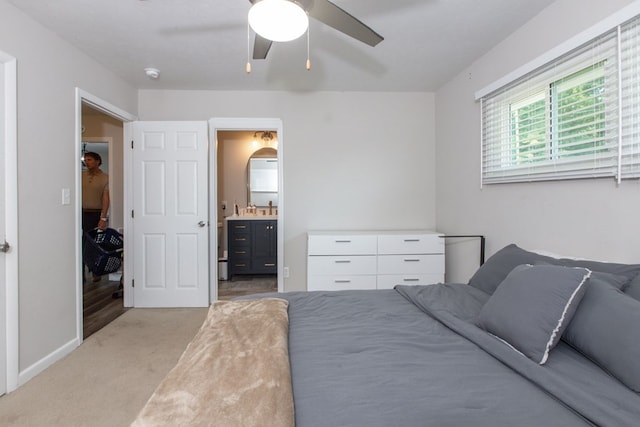 bedroom featuring ensuite bathroom, ceiling fan, and light colored carpet