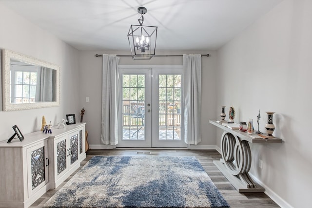 doorway to outside featuring hardwood / wood-style flooring, an inviting chandelier, and french doors