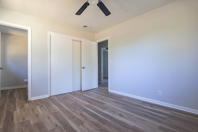 unfurnished bedroom with visible vents, baseboards, a closet, ceiling fan, and wood finished floors