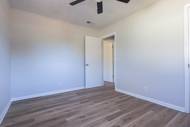 empty room featuring visible vents, baseboards, a ceiling fan, and wood finished floors