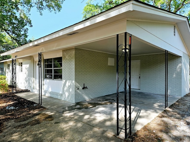 exterior space with brick siding and an attached carport