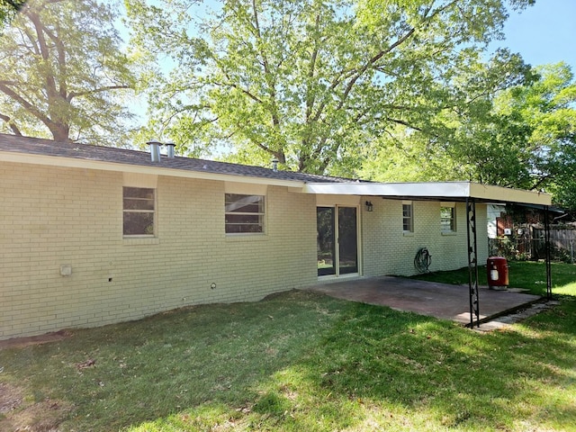 rear view of house featuring a patio, brick siding, and a lawn