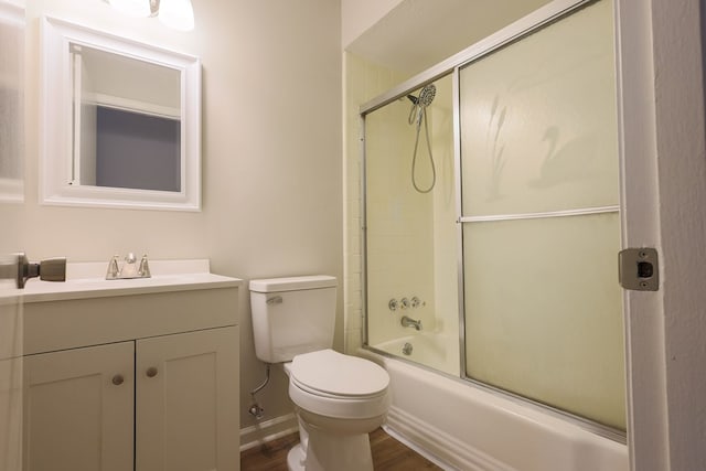 bathroom featuring bath / shower combo with glass door, vanity, toilet, and wood finished floors