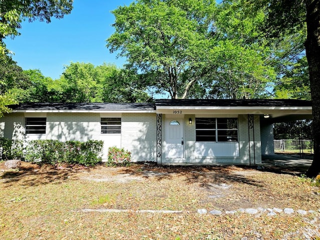 single story home featuring a carport and brick siding