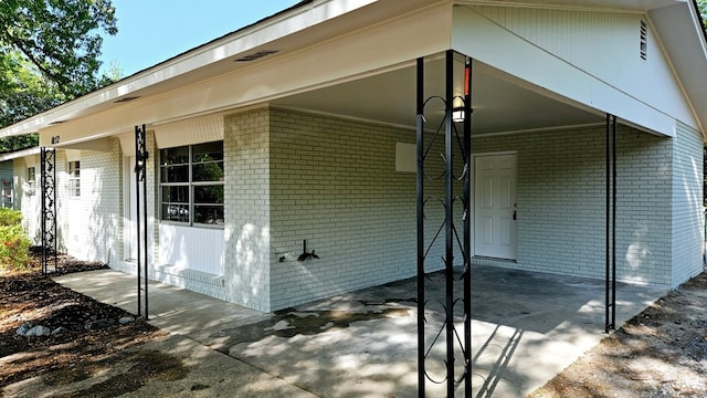 exterior space with an attached carport and brick siding
