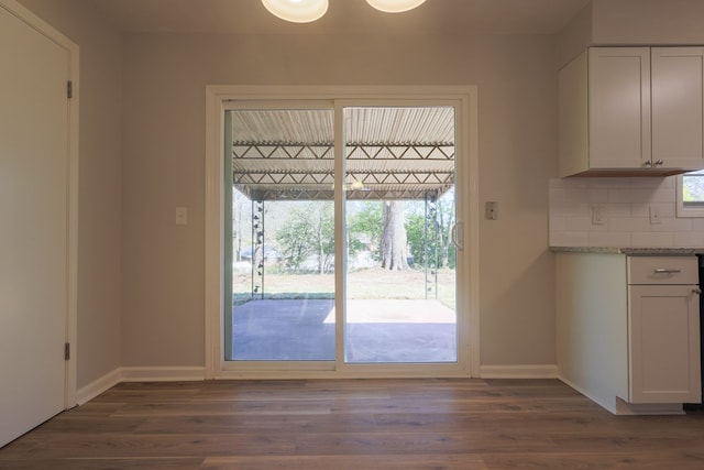 doorway to outside featuring a wealth of natural light, dark wood-style flooring, and baseboards