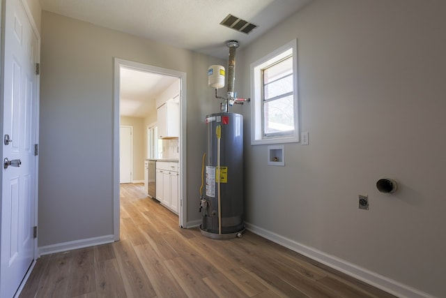 utility room with water heater and visible vents